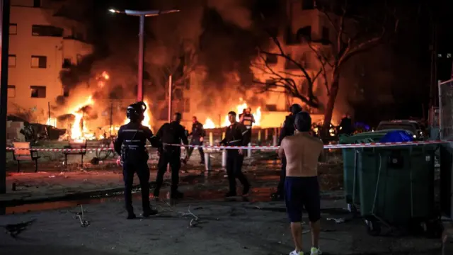 Rescue workers survey a fire after a missile attack