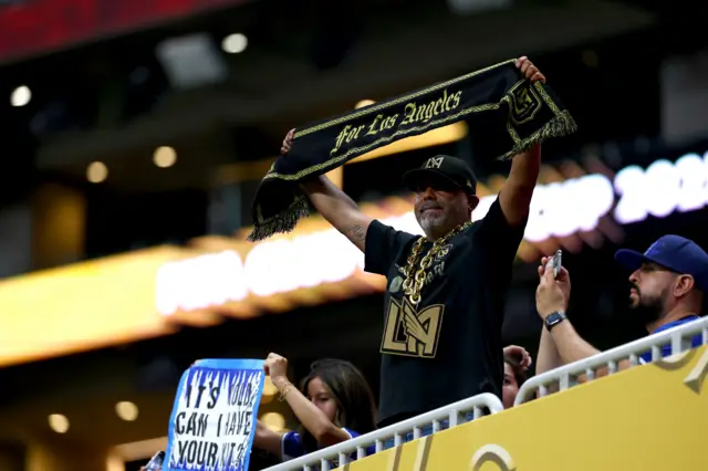 LA FC fan holds a scarf up in the stands