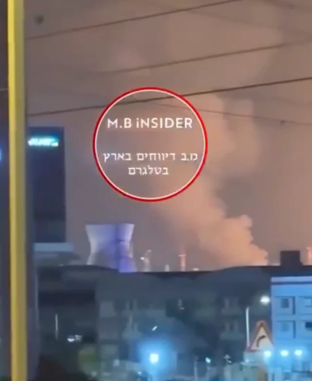Smoke can be seen rising from above what appears to be a large oil refinery in Haifa
