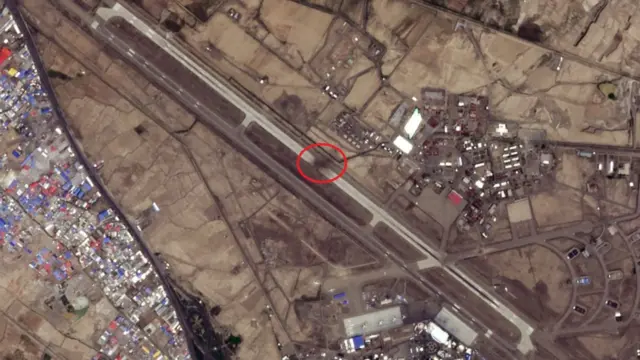 A satellite image shows a crater on an airport runway