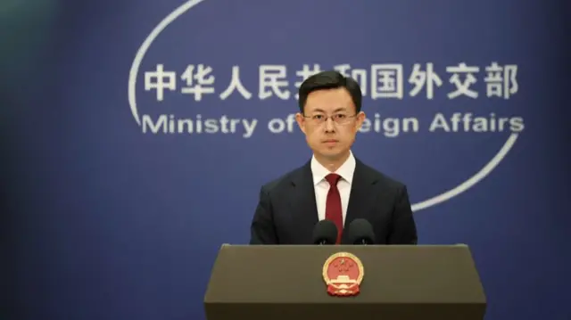 Guo Jiakun stands behind a lecturn