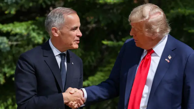 Donald Trump, in a dark suit and red tie, shakes hands with Carney