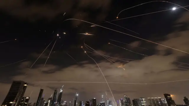 Photo appears to show several missiles in the air in the night sky above buildings.