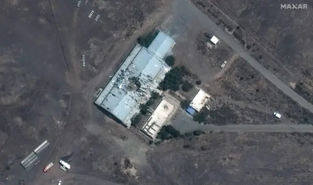 A satellite image shows a building in Iran that was hit in an apparent strike; you can see damage in the centre of the building, with what appears to be a large hole