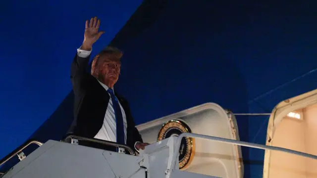 Donald Trump waves as he boards Air Force One after leaving the G7 Leaders' Summit early