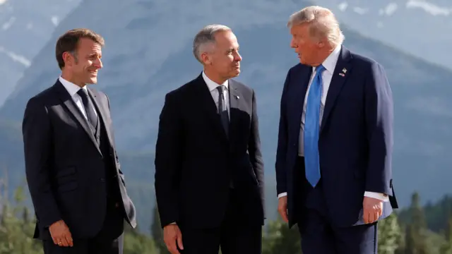 U.S. President Donald Trump, Canada's Prime Minister Mark Carney and France's President Emmanuel Macron talk during a family photo at the G7 Summit in Kananaskis, Alberta, Canada