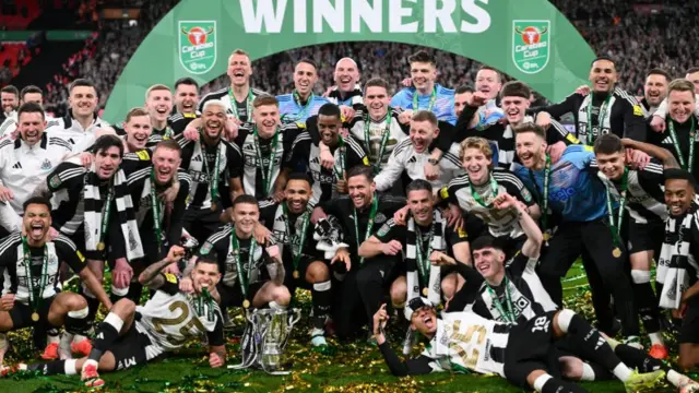 The Newcastle United squad and members of the coaching staff celebrate in a team picture after the Carabao Cup Final