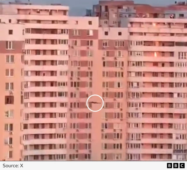 We have circled the drone in white moments before it strikes the apartment block causing a massive ball of fire