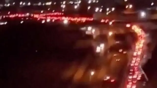 Heavy traffic moves slowly on an arterial road leaving Tehran.