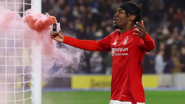 Anthony Elanga of Nottingham Forest celebrates whilst holding a red smoke flare