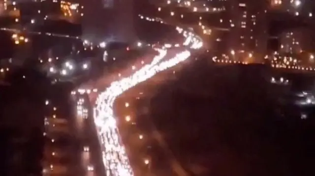 Heavy traffic moves slowly on an arterial road leaving Tehran.