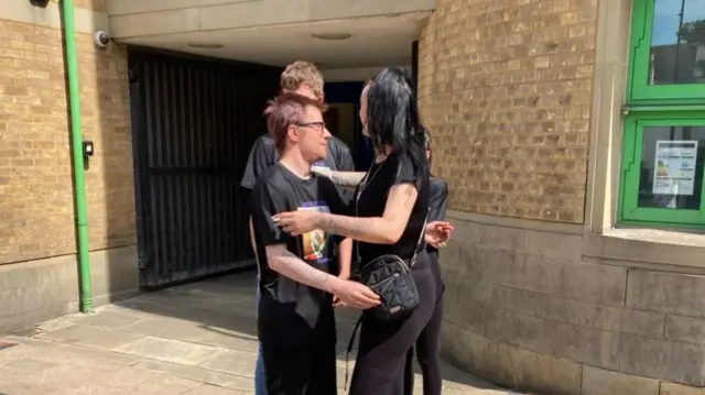 A man and woman hug outside Luton Crown Court.