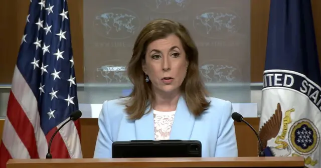 Tammy Bruce speaks with a US flag behind her