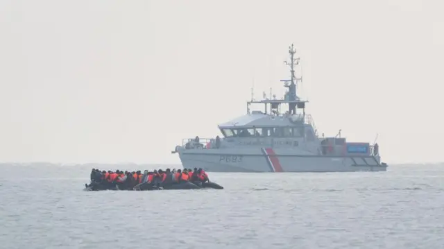 A group of people thought to be migrants onboard a small boat leaving the beach at Gravelines, France,