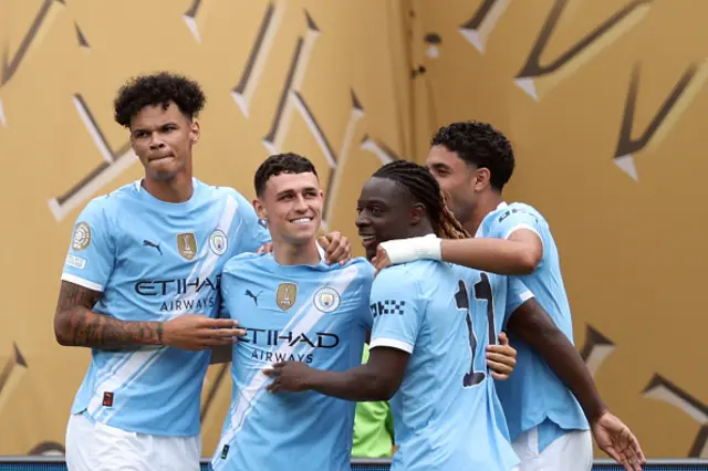 Phil Foden (2ndL) is congratulated by teammates
