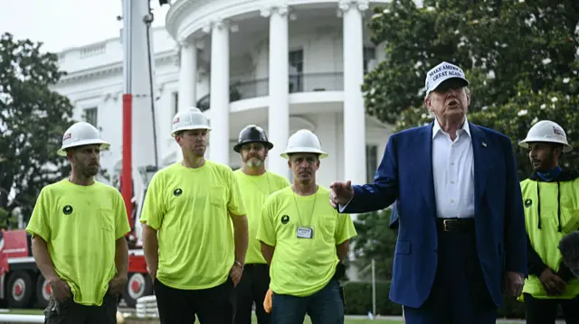 US President Donald Trump speaks to the press as workers install a large flag pole on the South Lawn of the White House in Washington, DC on June 18, 2025
