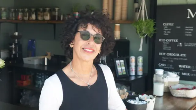 A woman stading in a coffee booth