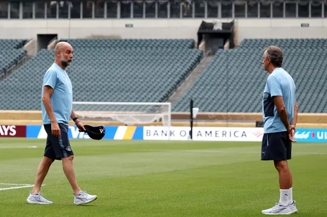 Manchester City's Spanish head coach Pep Guardiola (L) walks on the pitch