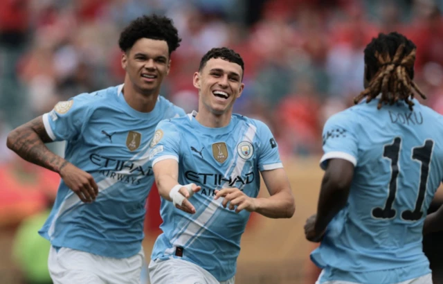 Manchester City's Phil Foden celebrates scoring their first goal with Nico O'Reilly and Jeremy Doku