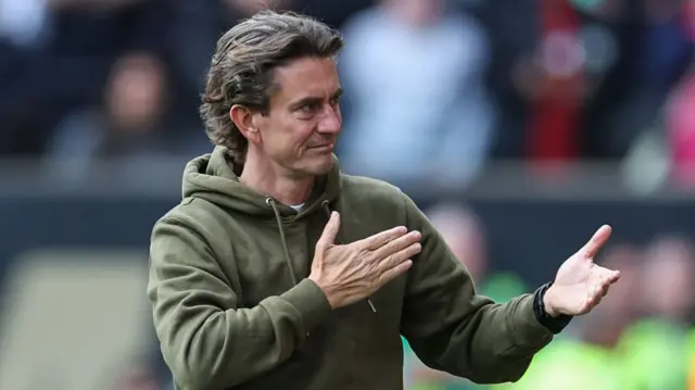 Brentford manager Thomas Frank pats the badge on his top