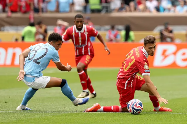 Rico Lewis #82 of Manchester City battles for possession with Oussama Zemraoui