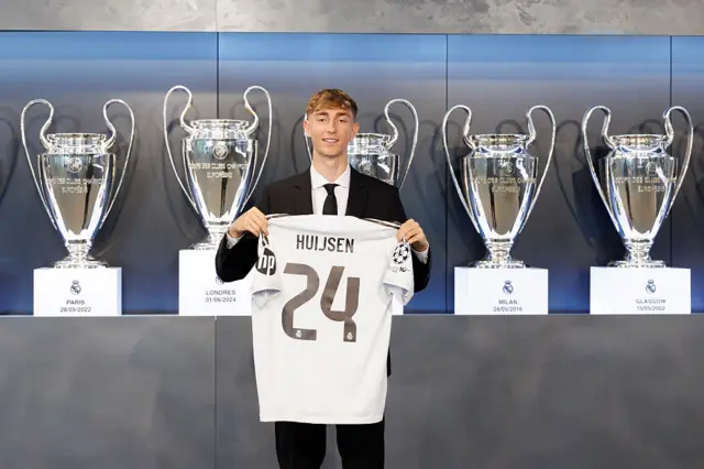 Dean Huijsen holding a Real Madrid shirt