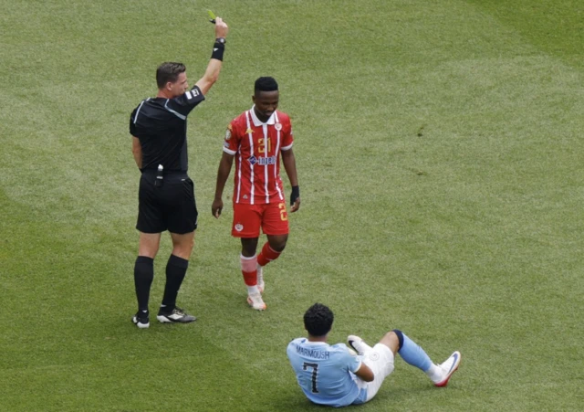Wydad Casablanca's Cassius Mailula is shown a yellow card by referee Ramon Abatti Abel