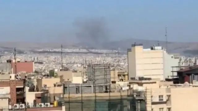 A wispy cloud of black smoke in the air over Tehran