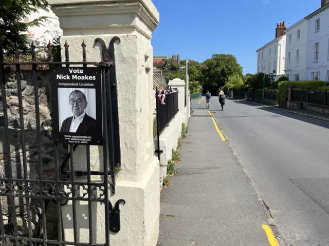 A voting sign on a gate