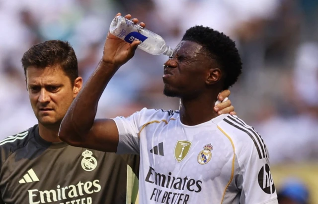 Real Madrid's Aurelien Tchouameni pours water on his face to cool down during a break in play