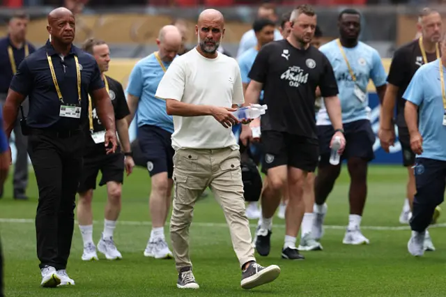 Pep Guardiola walks on the pitch