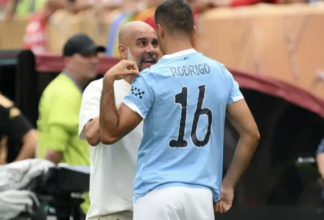 Pep Guardiola speaks to Rodri