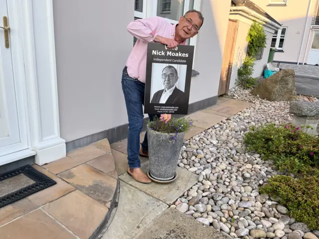 Deputy Nick Moakes removing one of his posters