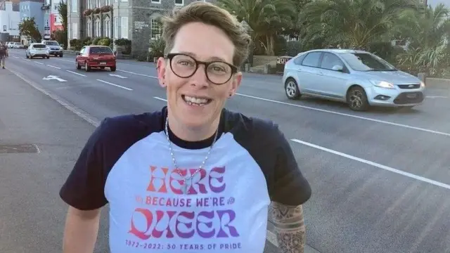 Ellie Jones wearing a Pride t-shirt and stood on a street