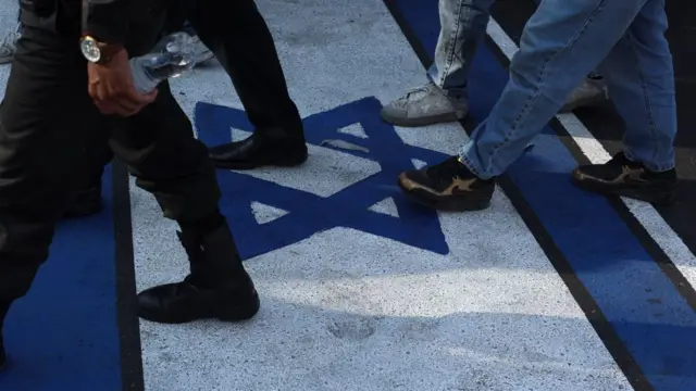 People walk on an Israeli flag in Tehran (15/06/25)