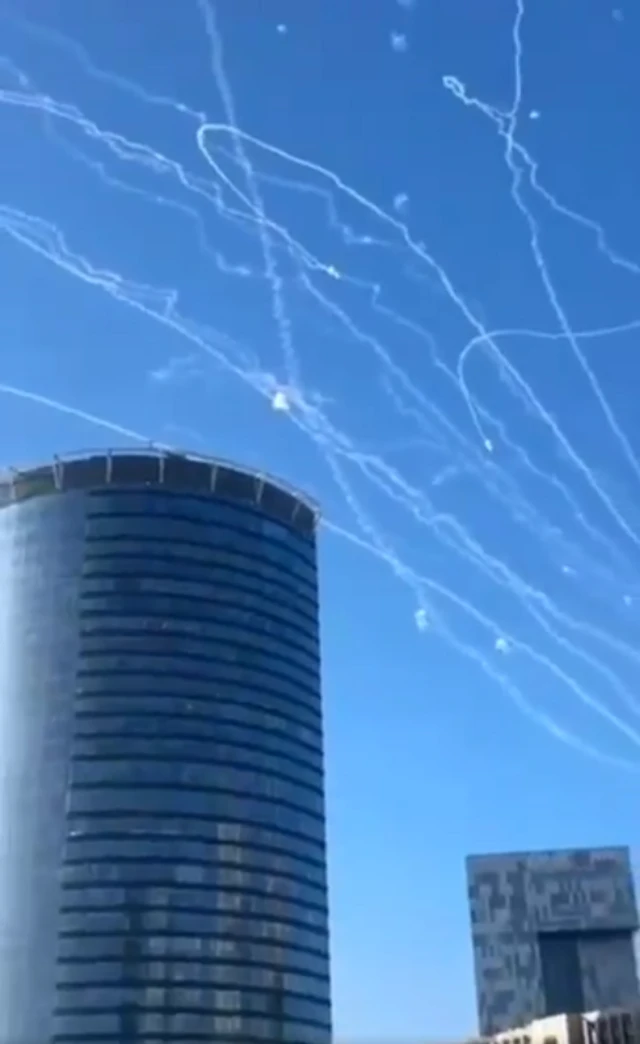 Multiple vapour trails are seen in the sky above Tel Aviv