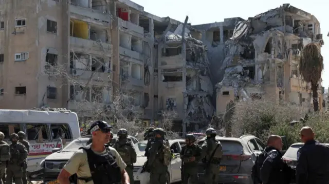 Emergency personnel gather at an impact site following a missile strike from Iran on Israe