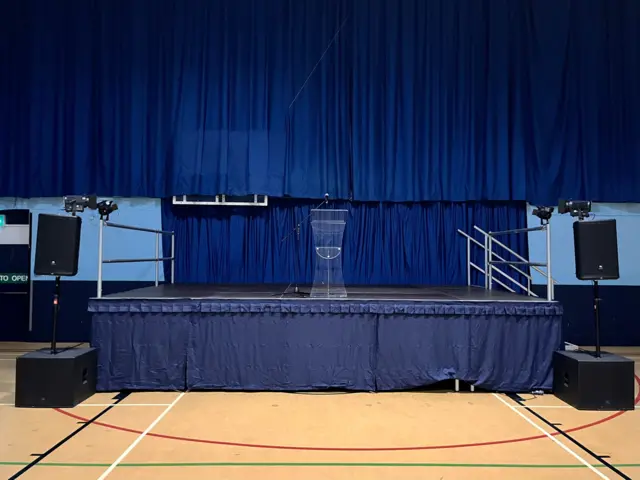 A stage draped in blue cloth