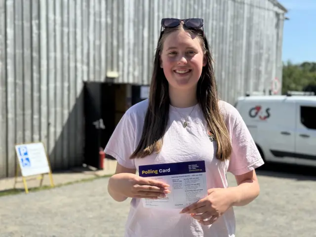 Arwen Langlois stood in front of a polling station holding her polling card