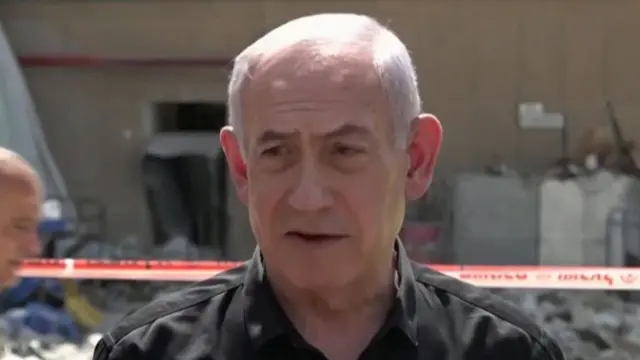 Israeli Prime Minister Benjamin Netanyahu speaking at the site of a damaged hospital