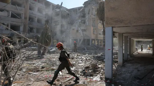 Israeli emergency teams work at the site of an Iranian missile strike in a residential area in Holon