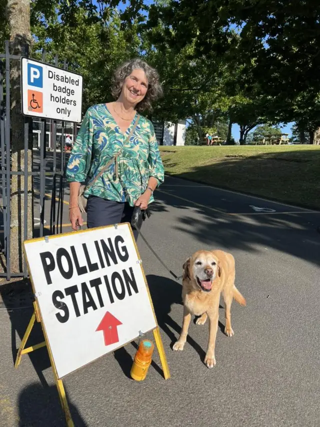 Jennifer Strachan stood with her dog by a polling station sign