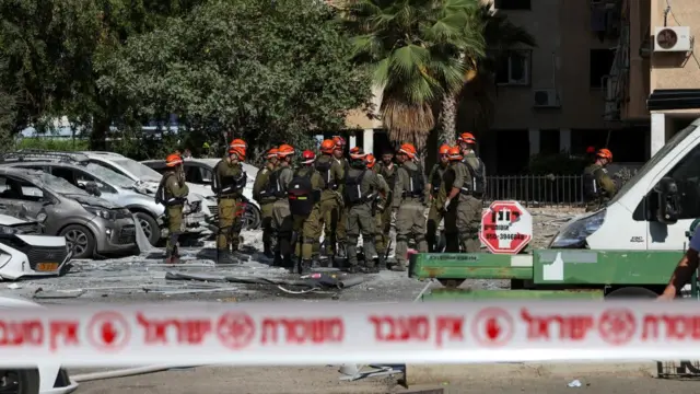 Emergency personnel gather at an impact site following a missile strike from Iran on Israel, in Holon, Tel Aviv, Israel June 19, 2025
