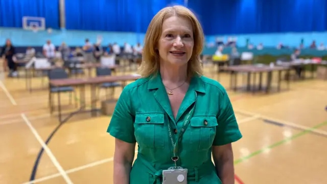 Colette Falla wearing a green dress stood in the counting room.