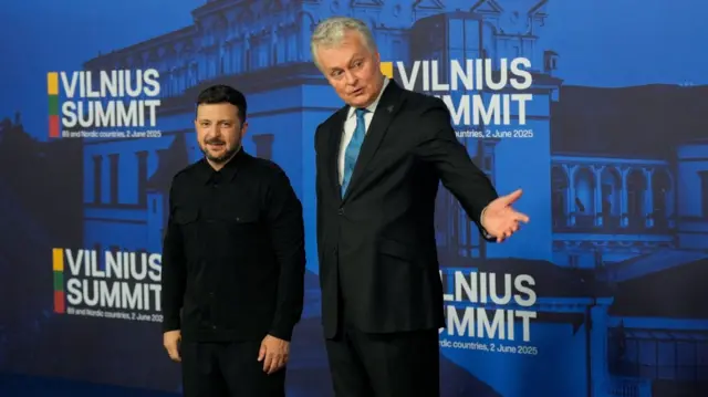 Volodymyr Zelensky (L) stands next to Lithuanian President (R) as he arrives at Nato summit