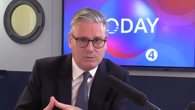 Starmer speaking to the Today programme. He is speaking into a microphone and wearing a suit