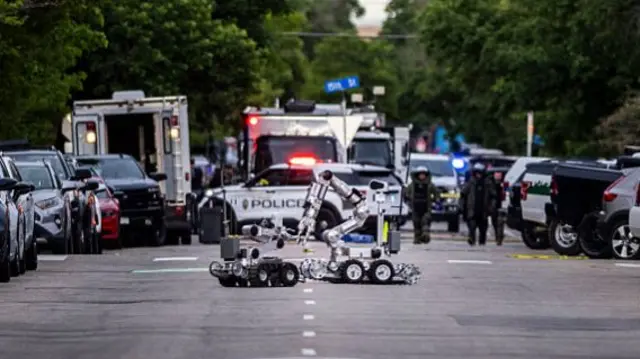 Anti-bomb robotics on a road lined with cars in Boulder, Colorado.