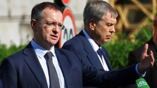 Russian delegate Vladimir Medinsky addresses press outside while in a dark blue suit