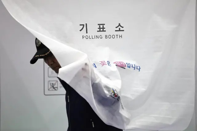 A man leaves a voting booth in Seoul, South Korea.