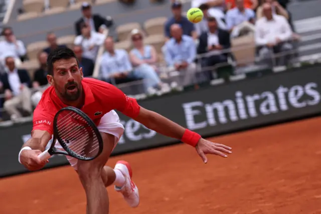 Djokovic reaching forward for the ball
